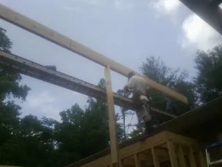 Carpenter setting a ridge beam over a new addition frame — Ice Dam Removal by Roofing Brothers in Scotts Valley