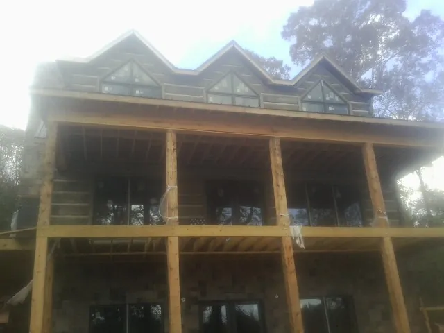 Dormers and porch framing on a large log home under construction — Roof Coating work by our crew in Scotts Valley
